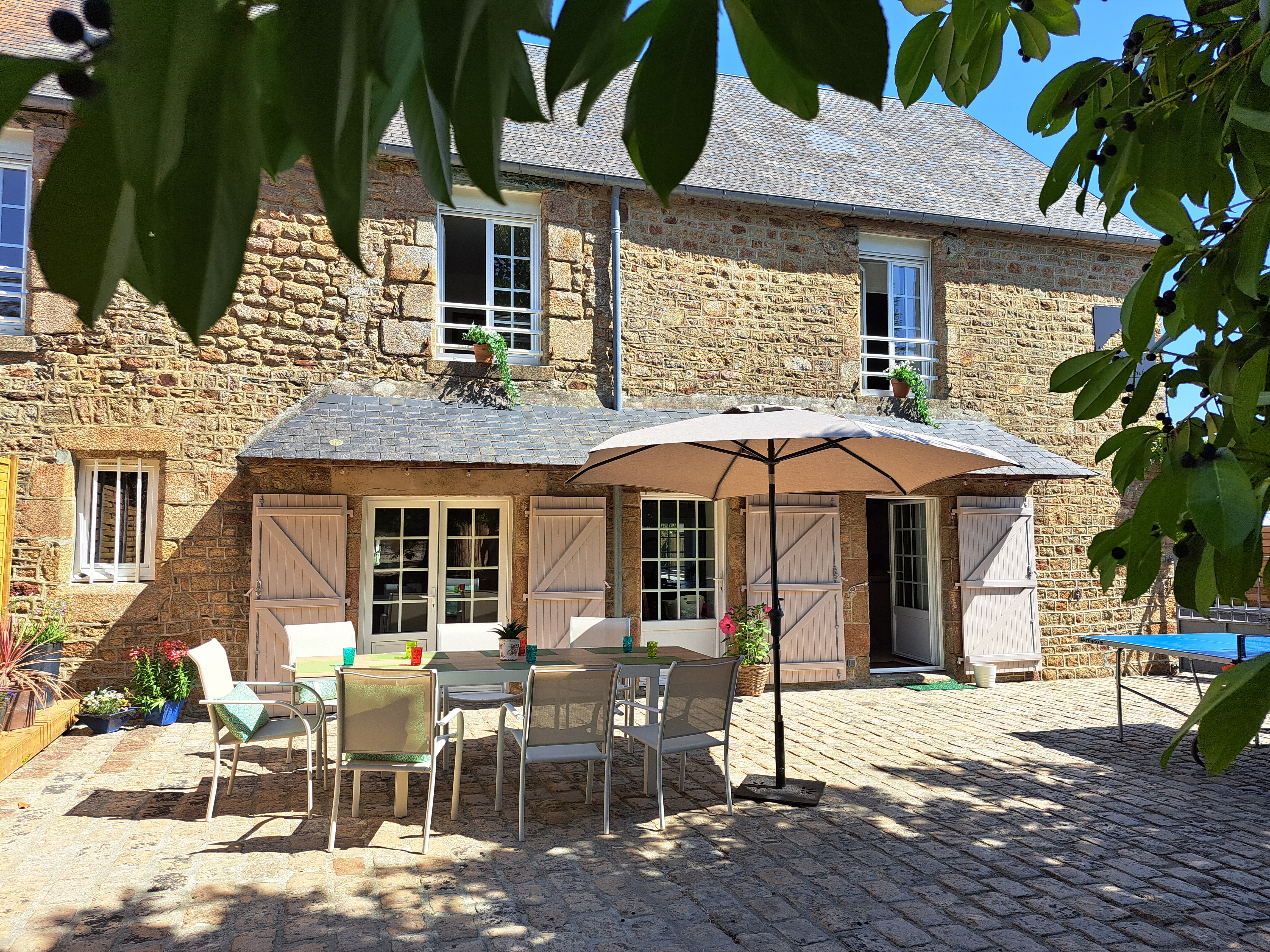 Photo de la façade de la maison, côté jardin, avec la terrasse