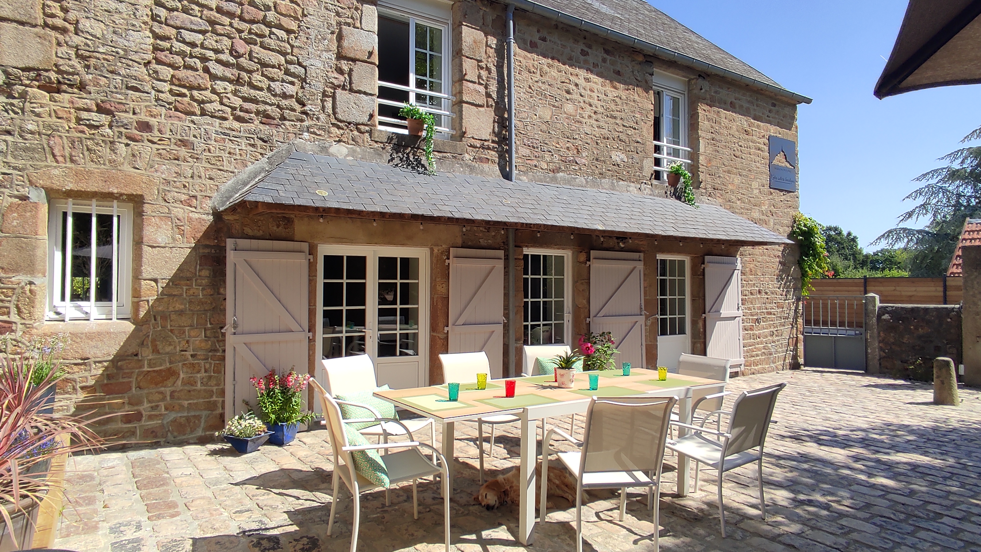 Photo de la façade de la maison, côté jardin, avec la terrasse